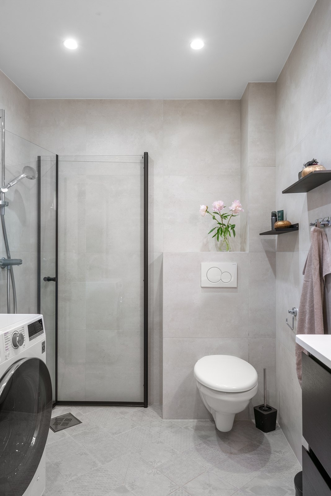 Badet består av vegghengt toalett, hjørnedusj, servant og opplegg til vaskemaskin. Galleribilde