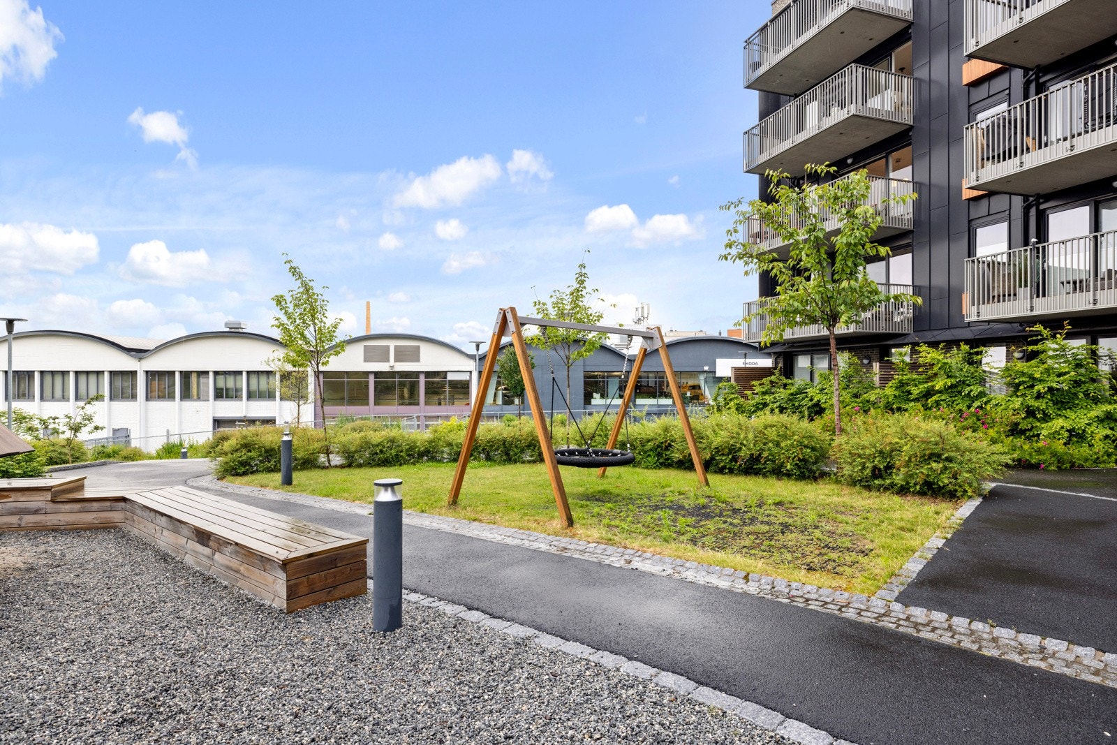 Fellesområdet har flere grønne plener og benker. Galleribilde