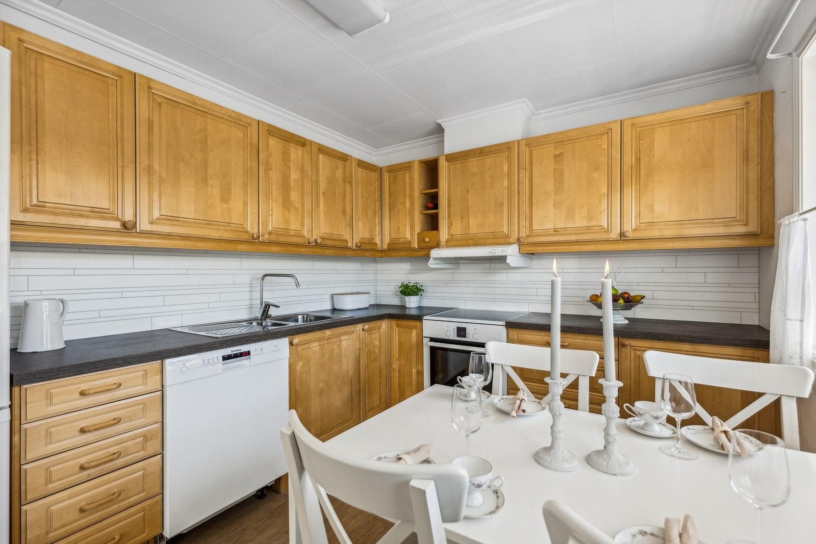 Kjøkkenet har innredning med profilerte fronter og frittstående hvitevarer. Galleribilde