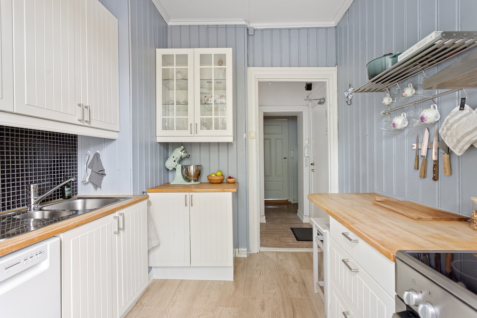 Innredningen har lyse fronter og benkeplate av tre med nedfelt oppvaskkum. Benkeskapsbelysning og stikkontakter under overskap. Galleribilde