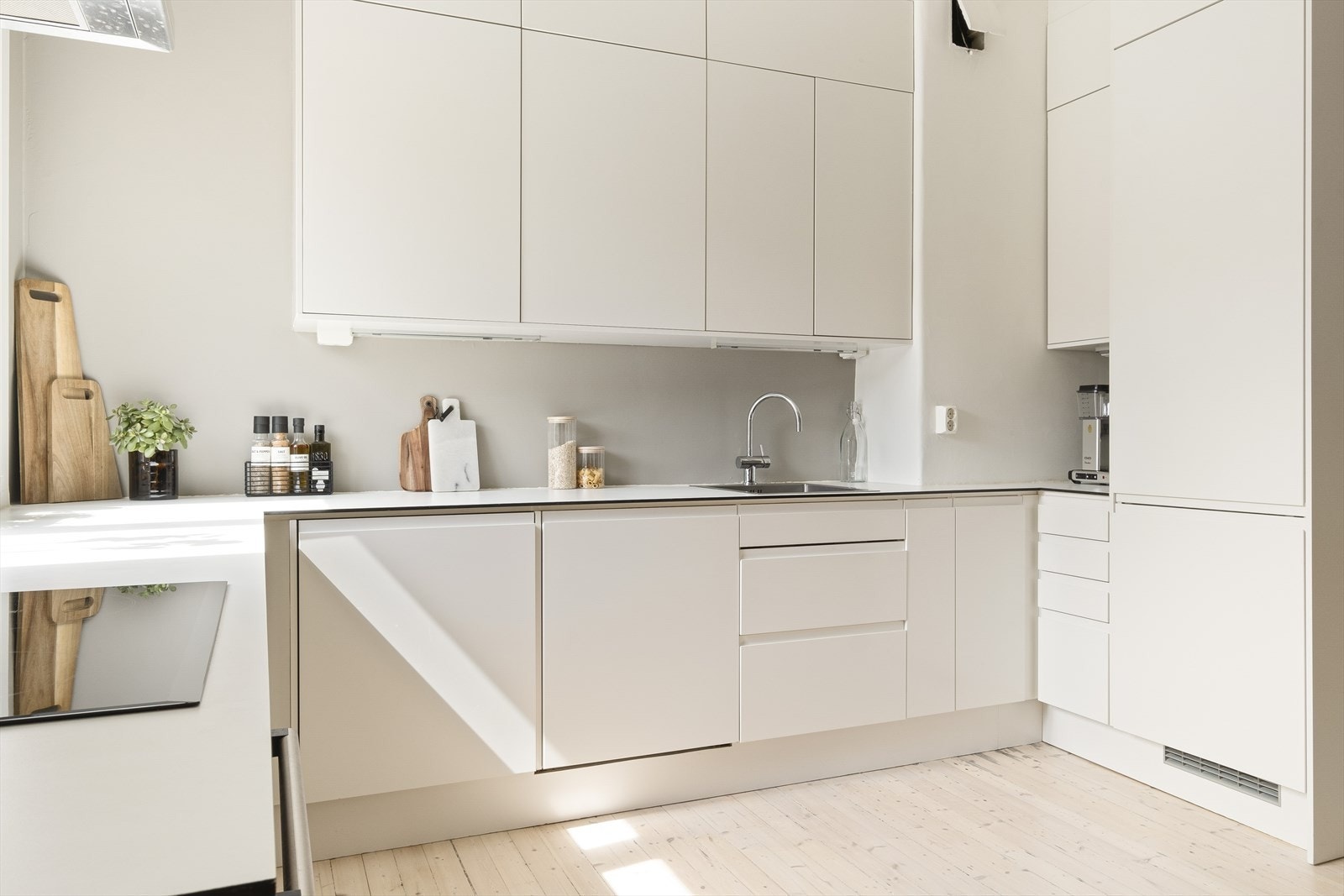 Innredningen har hvite, profilerte fronter og laminat benkeplate med nedfelt vaskekum. Kjøkkenet har integrert stekeovn, induksjonstopp, oppvaskmaskin, vaskemaskin og kombiskap med kjøl/frys. Det er montert ventilator over kokesonen med kullfilter. Galleribilde
