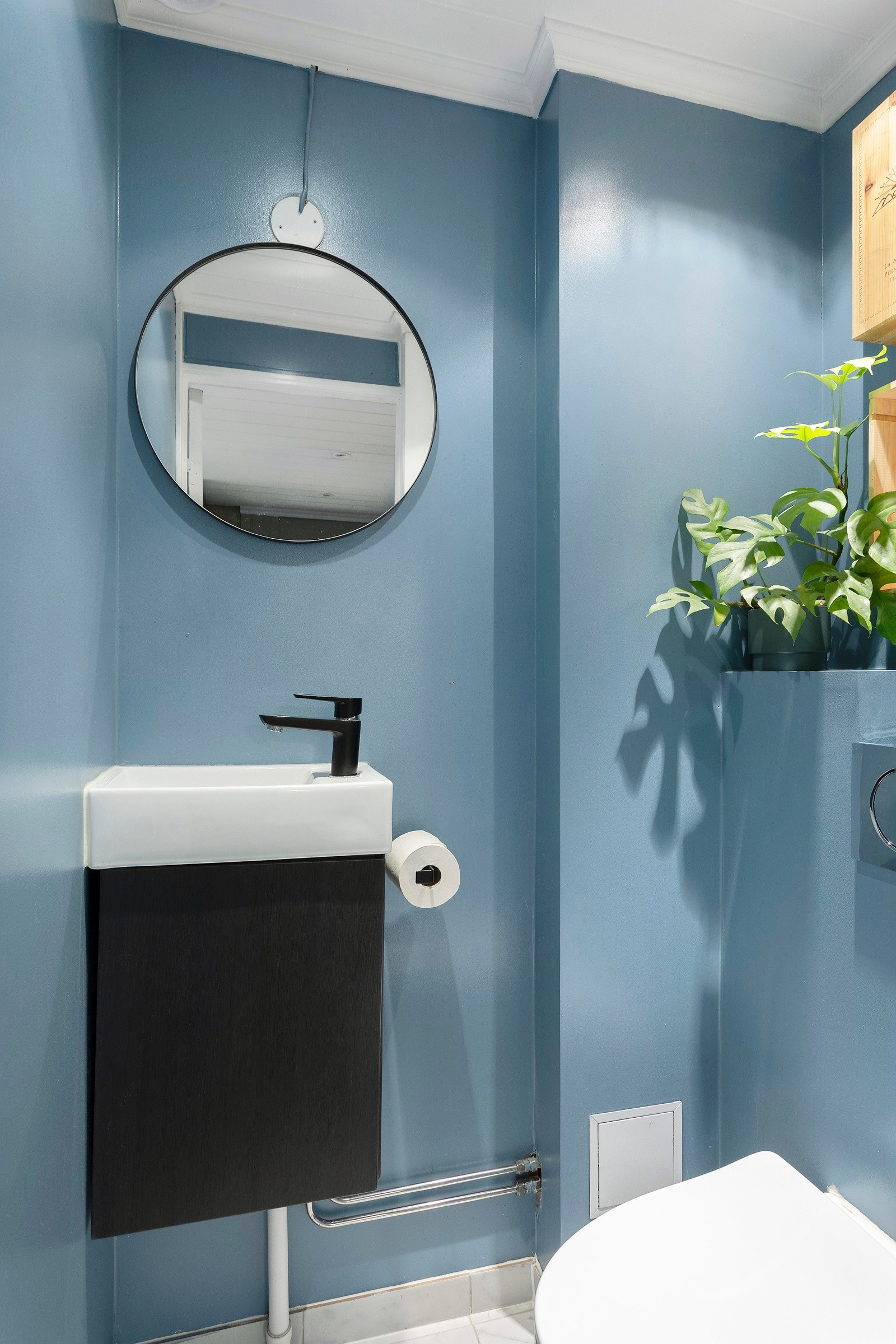 Wc-rom med veggmontert wc, servant med skapinnredning og speil. Galleribilde