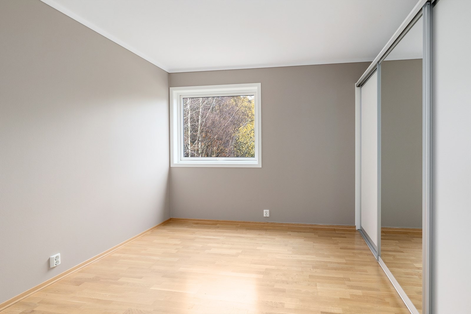 På det ene soverommet står det stor skyvedørsgarderobe Galleribilde