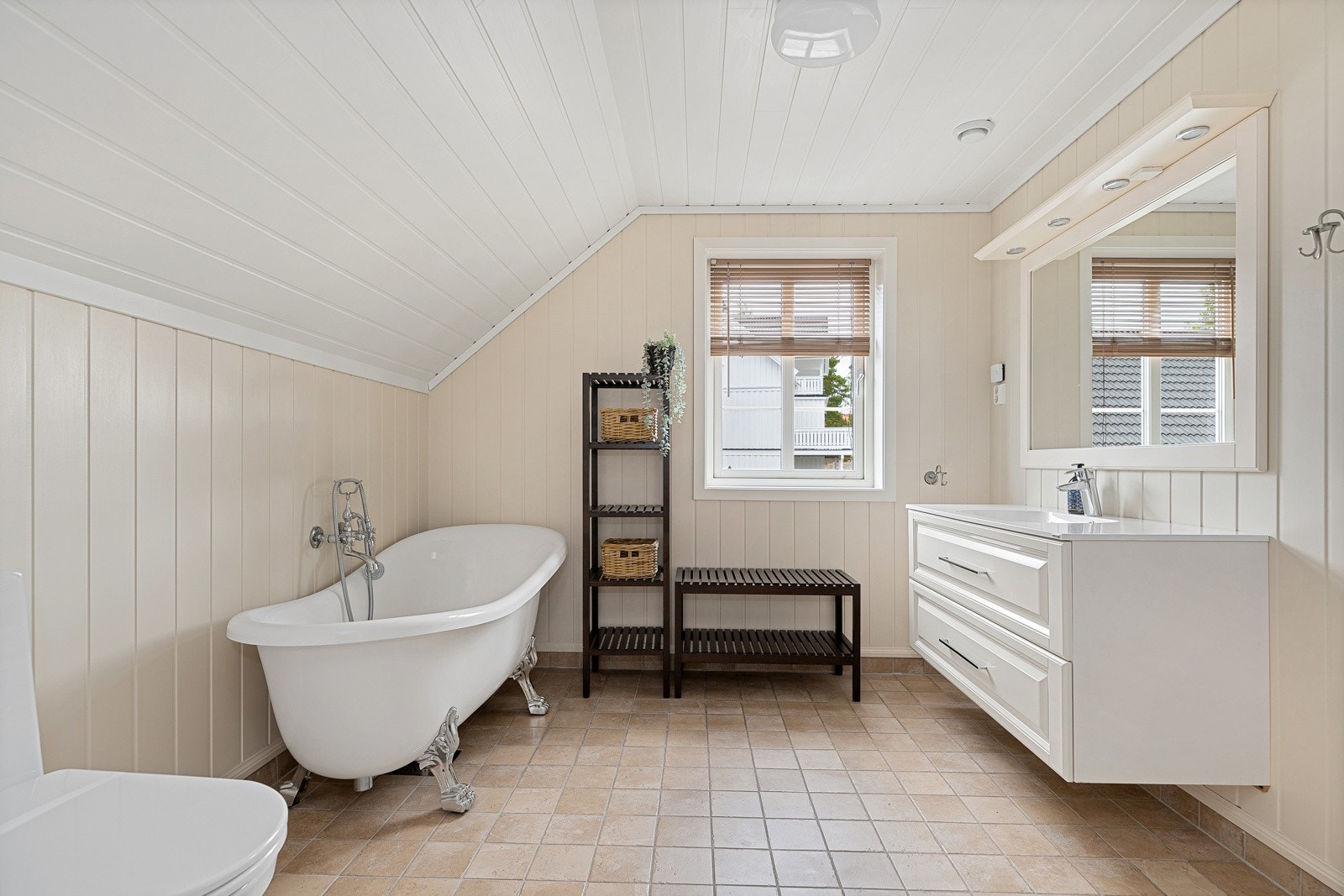 Baderommet er utstyrt med en innredning med nedfelt servant, toalett, og et lekkert badekar Galleribilde