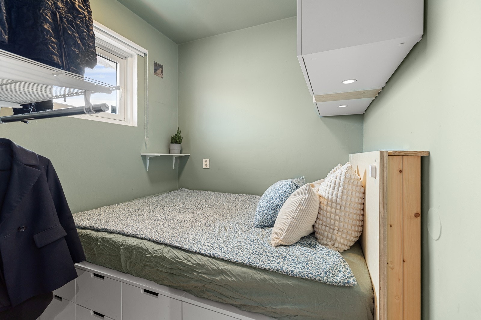 Det er skuffer under sengen samt vegghengte skap og hyller med mulighet for å henge opp klær Galleribilde