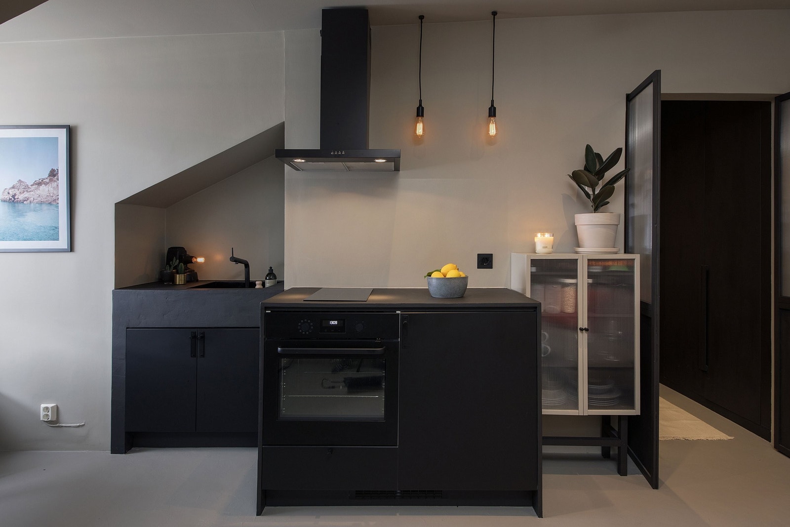 Praktisk kjøkken med kjøleskap med integrert fryser, integrert komfyr, platetopp, nedfelt oppvaskkum, samt liten benkeoppvaskmaskin montert i underskap. Galleribilde