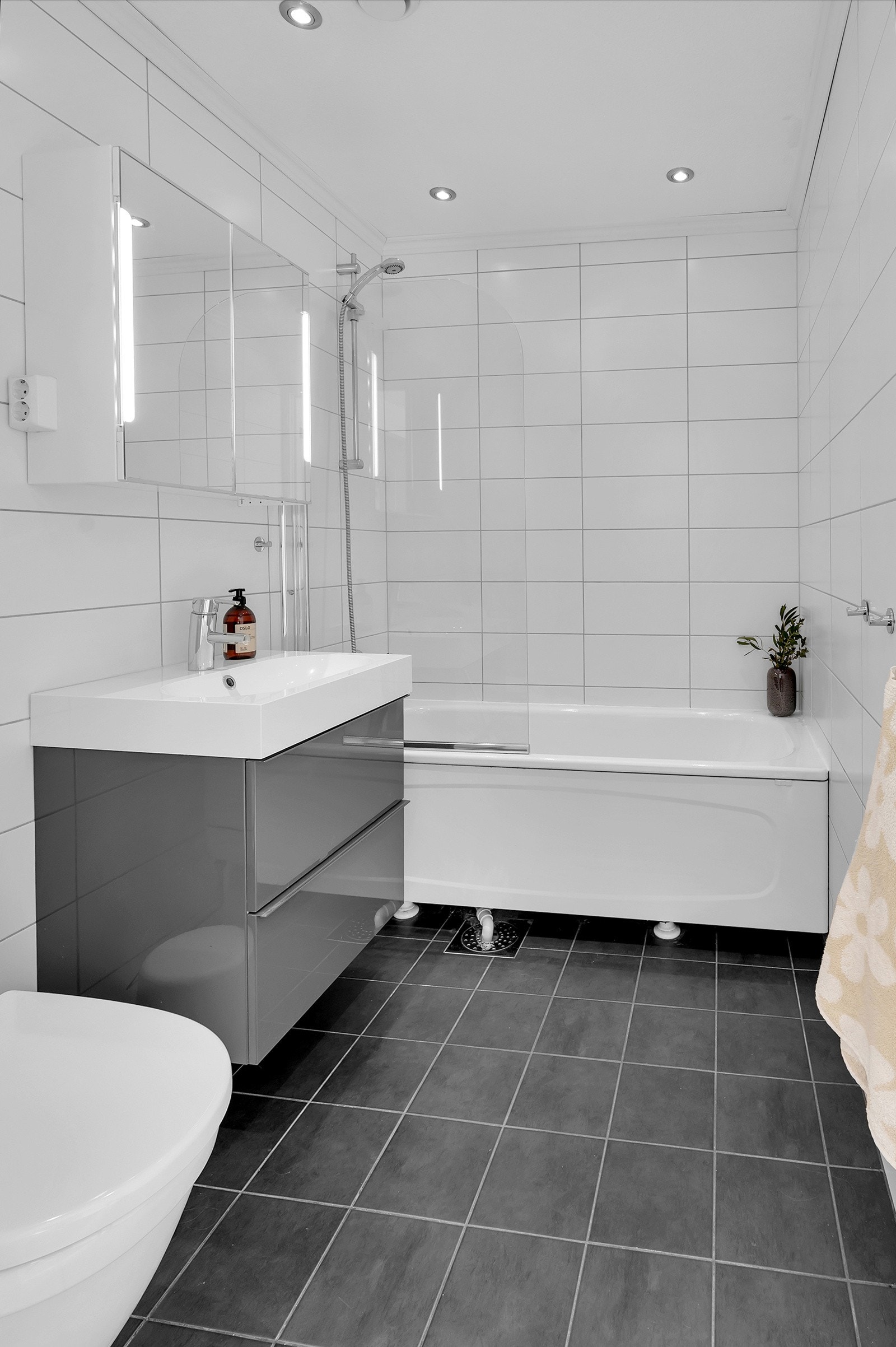Pent flislagt bad med badekar m/dusj, toalett og innredning med nedfelt servant. Varmekabler i gulv Galleribilde
