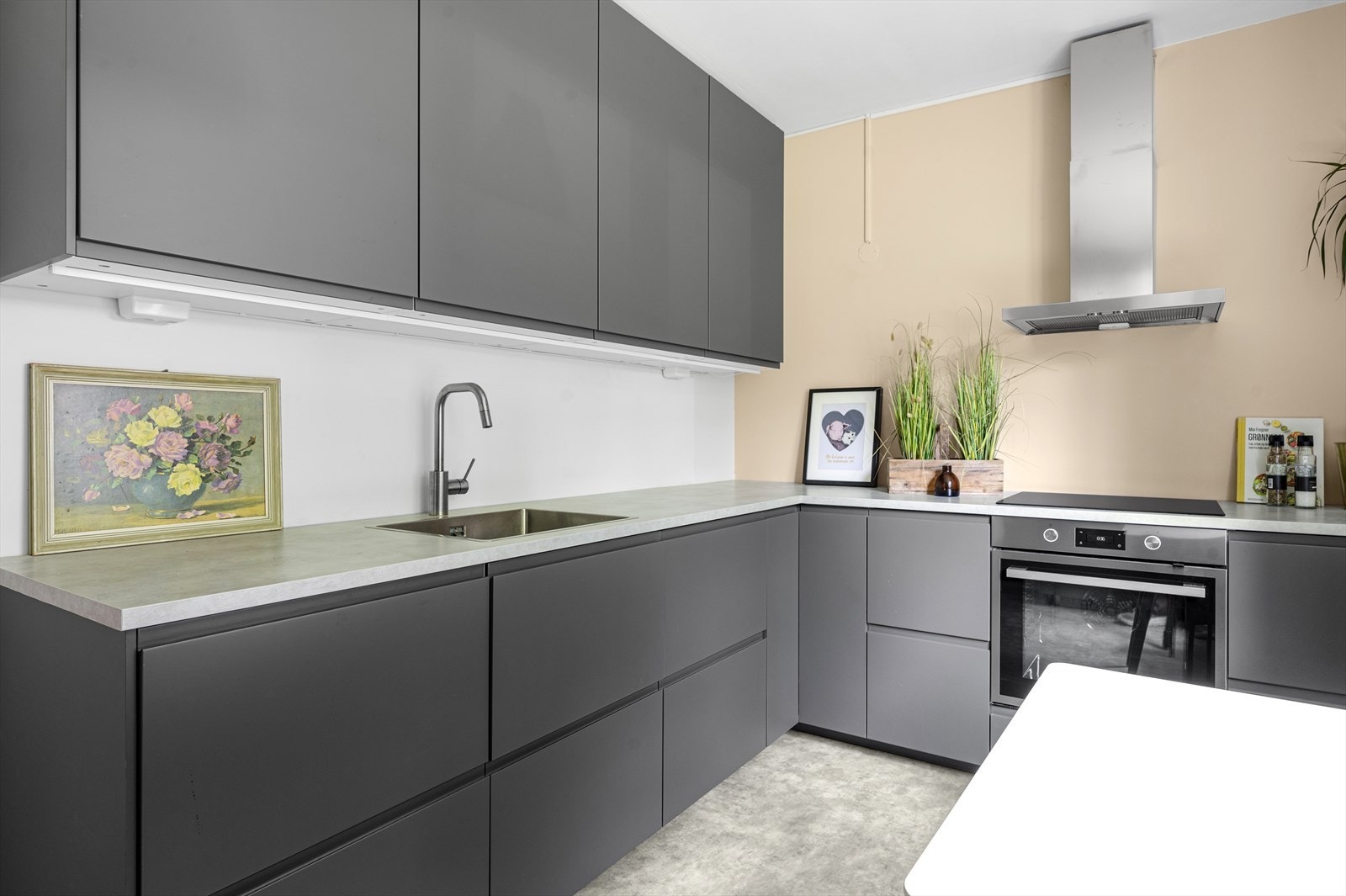 Kjøkkeninnredning med glatte fronter og benkeplate av laminat. Galleribilde