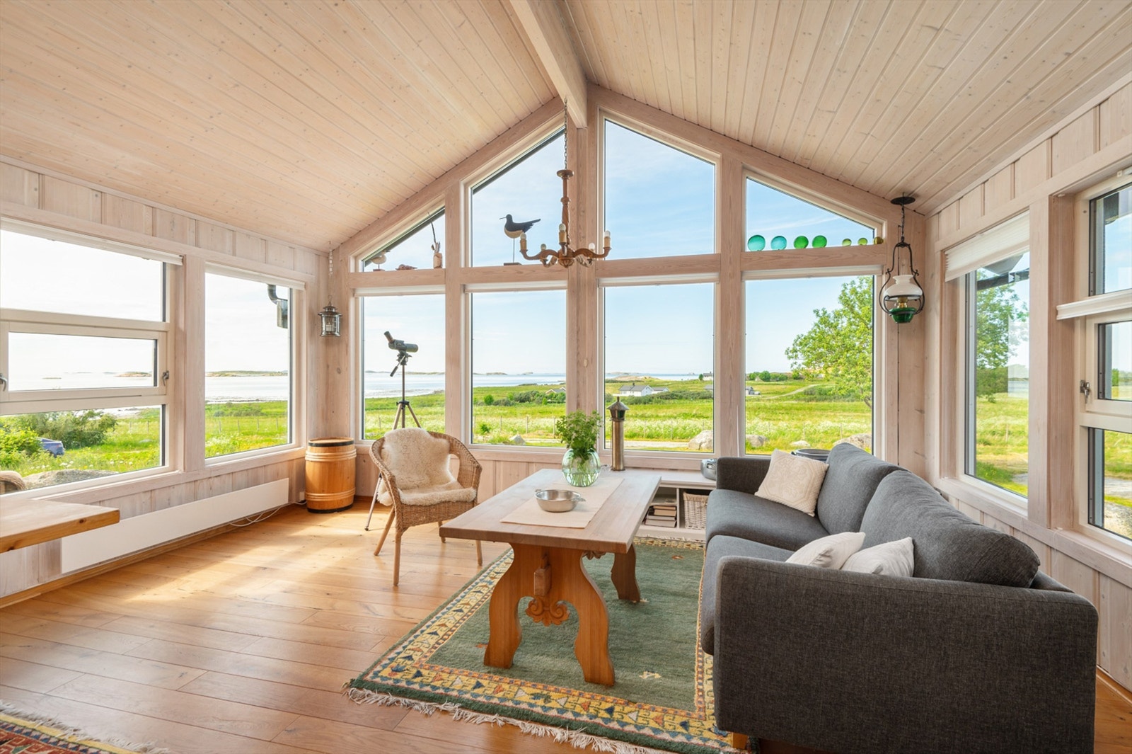 Heldekkende vindusflater i stua tar naturen og den vakre utsikten inn på stuegulvet. Galleribilde