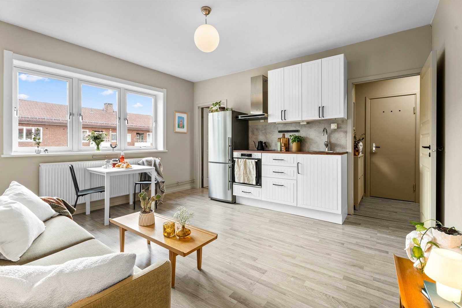 Kjøkkenet er i åpen løsning med stuen og har en innredning av profilerte, hvite fronter og benkeplate i laminat. Galleribilde