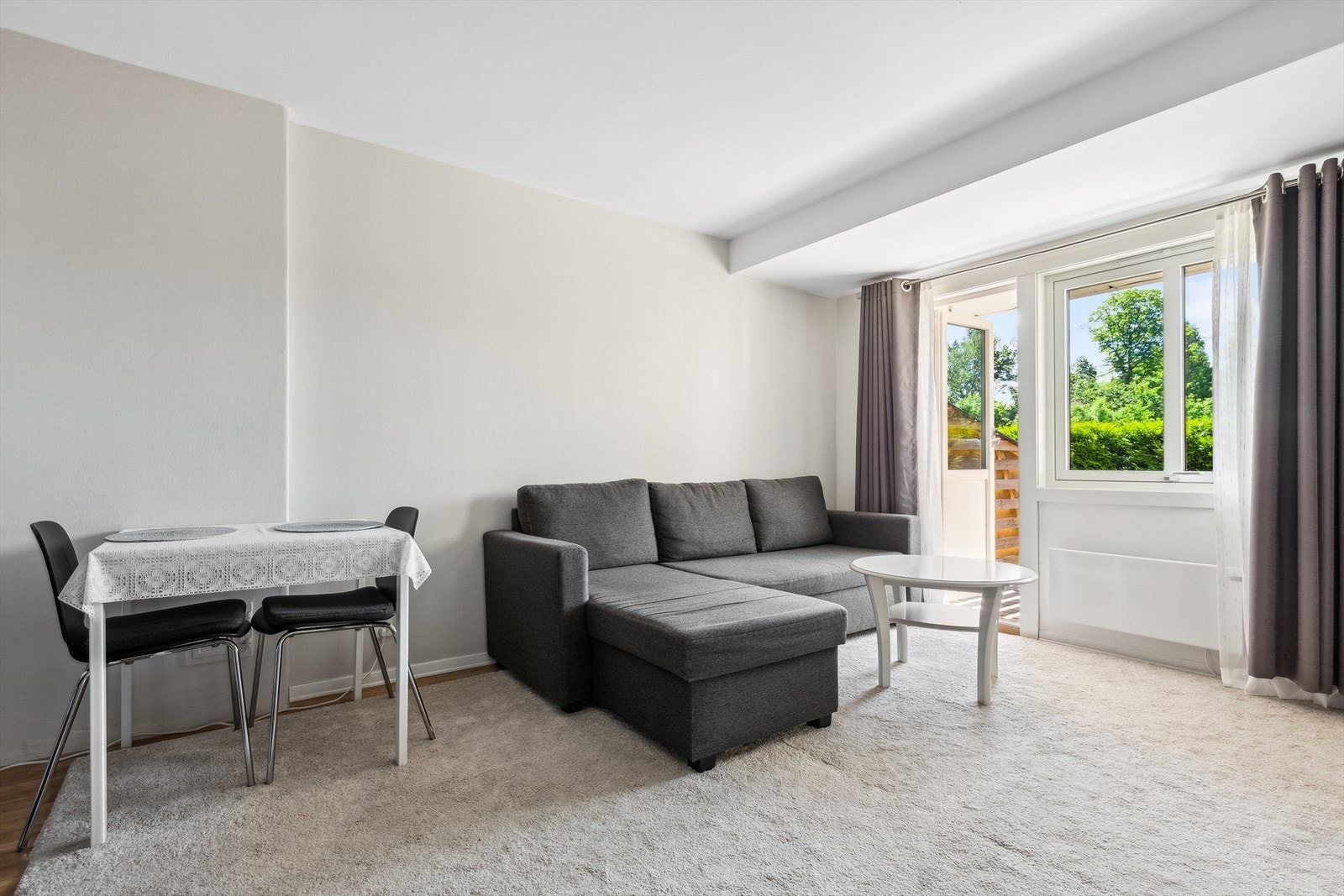 Stuen er lys med plass til både sofagruppe og spisebord. Galleribilde