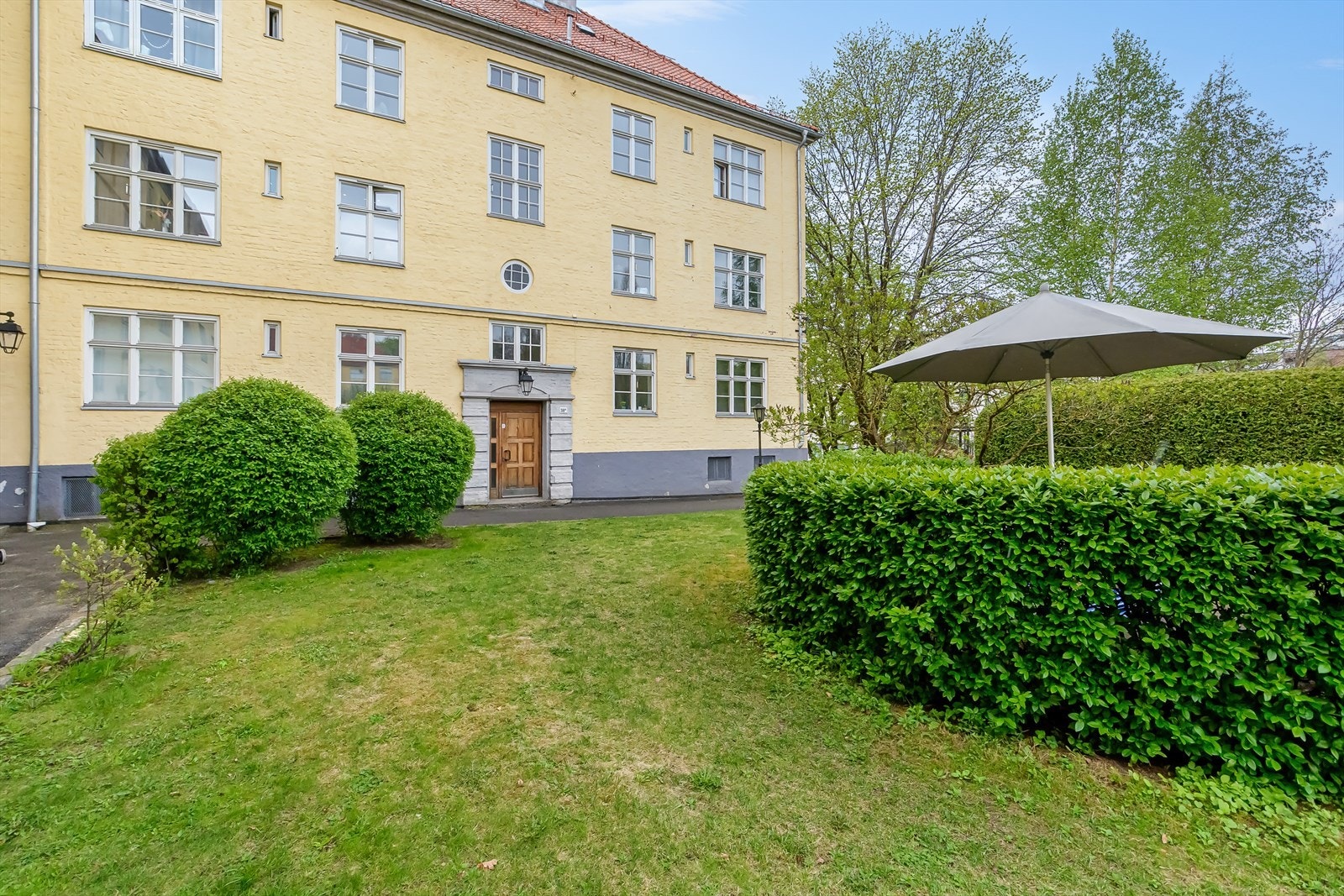 Meget pen bygård med forhage og prydbusker. Galleribilde