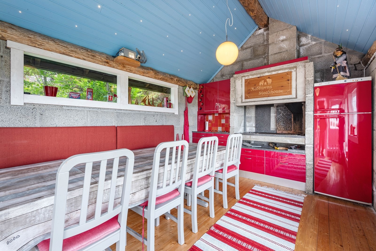 Grillhuset har eget kjøkken, og her samles venner og familie for hyggelige måltider rundt et langbord - Merk stjernehimmelen i taket Galleribilde