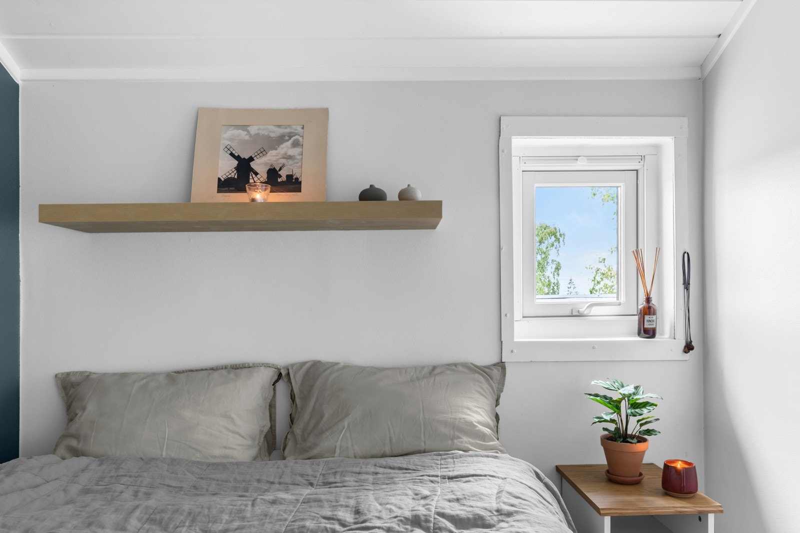 Rommet har plass til stor seng, nattbord og diverse hyller. Et lite vindu og god takhøyde sørger for en god atmosfære Galleribilde