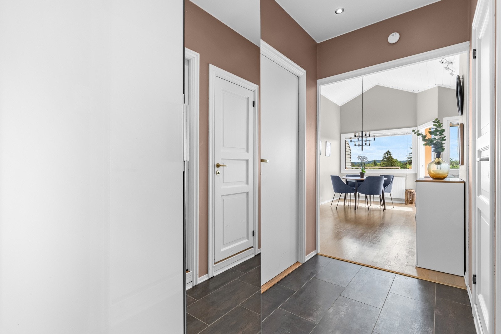 Entréen binder stue, alkove, bad og kjøkken sammen - malt i en trendy fargetone. Galleribilde