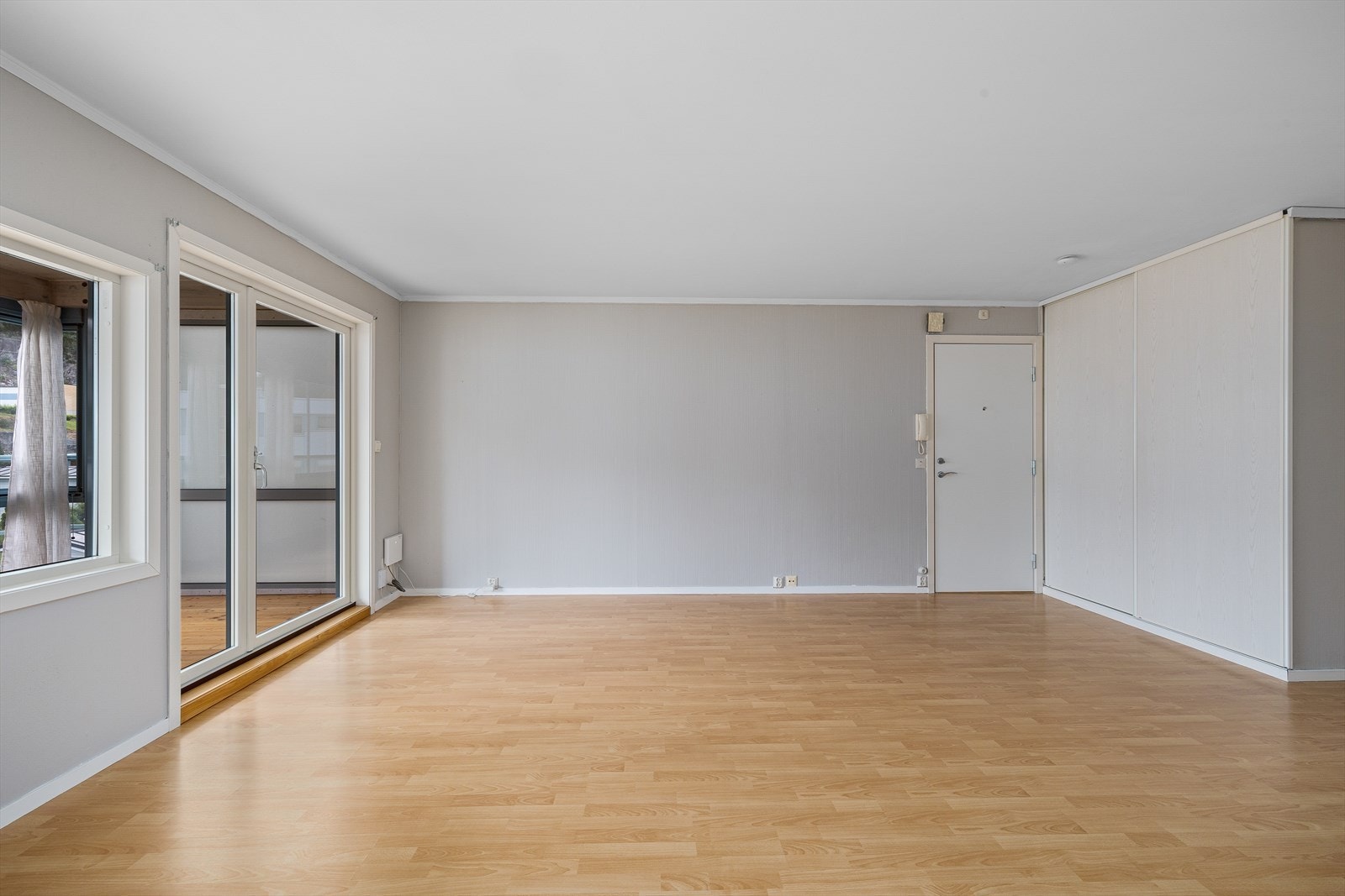 Stor, lys stue med utgang til innglasset balkong Galleribilde