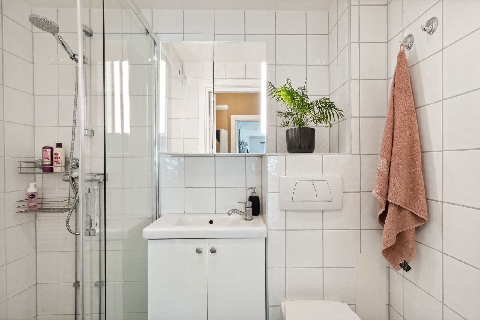 Flislagt bad med varme i gulvet og dusjvegg i glass. Galleribilde