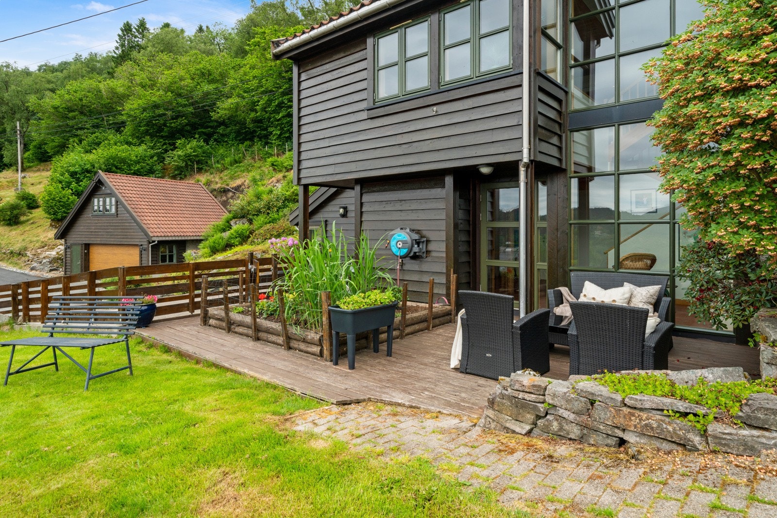 Eiendommen er pent opparbeidet med flere utvendige oppholdsområder Galleribilde