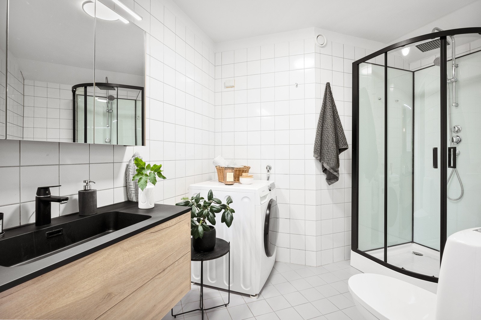 Badet fikk ny servantinnredning og dusjkabinett i 2022, i trendy sort som skaper en fin kontrast til hvite overflater. Galleribilde
