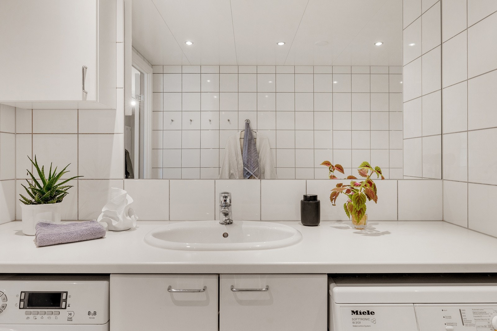 Baderomsinnredning med laminert benkeplate med nedsenket servant og stort innmurt speil. Galleribilde