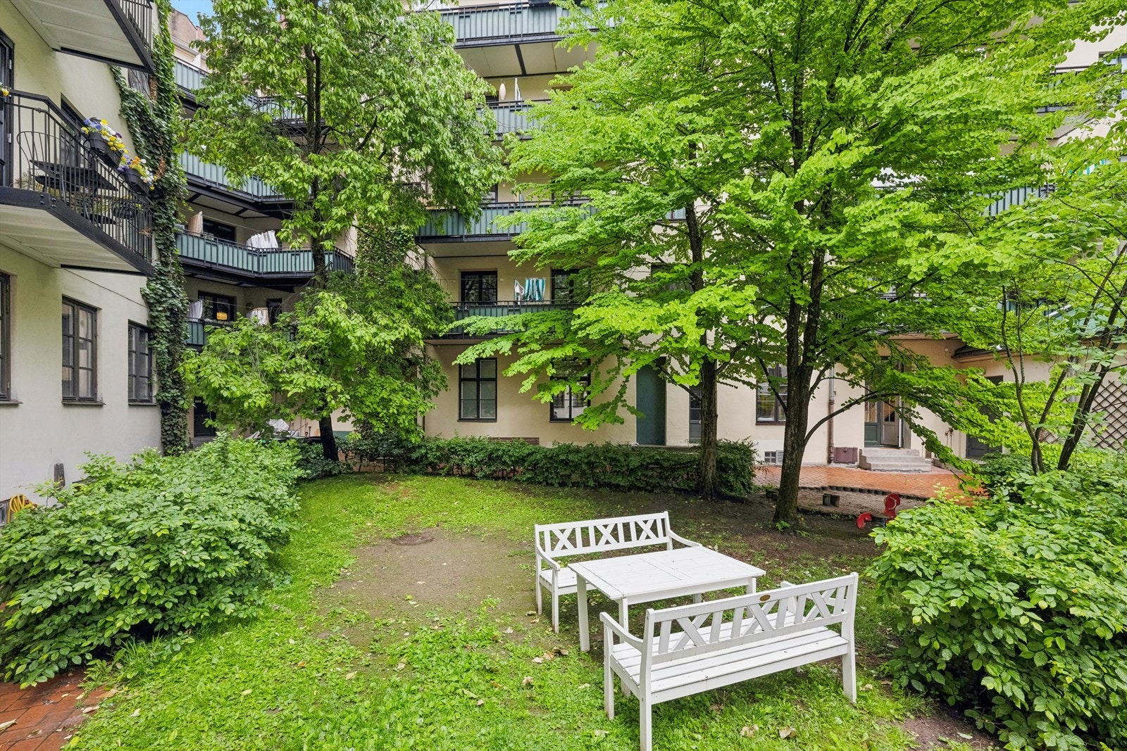 Hyggelig bakgård med sittegrupper og lekeapparater Galleribilde