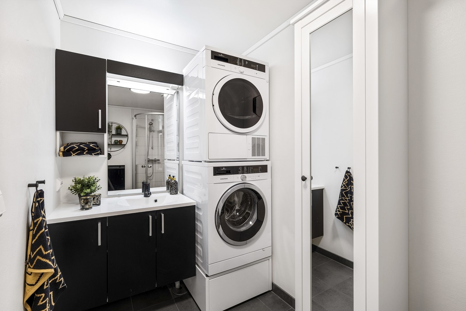 Flott flislagt bad med moderne innredning, god lagringsplass, vegghengt toalett og dusjhjørne. Galleribilde