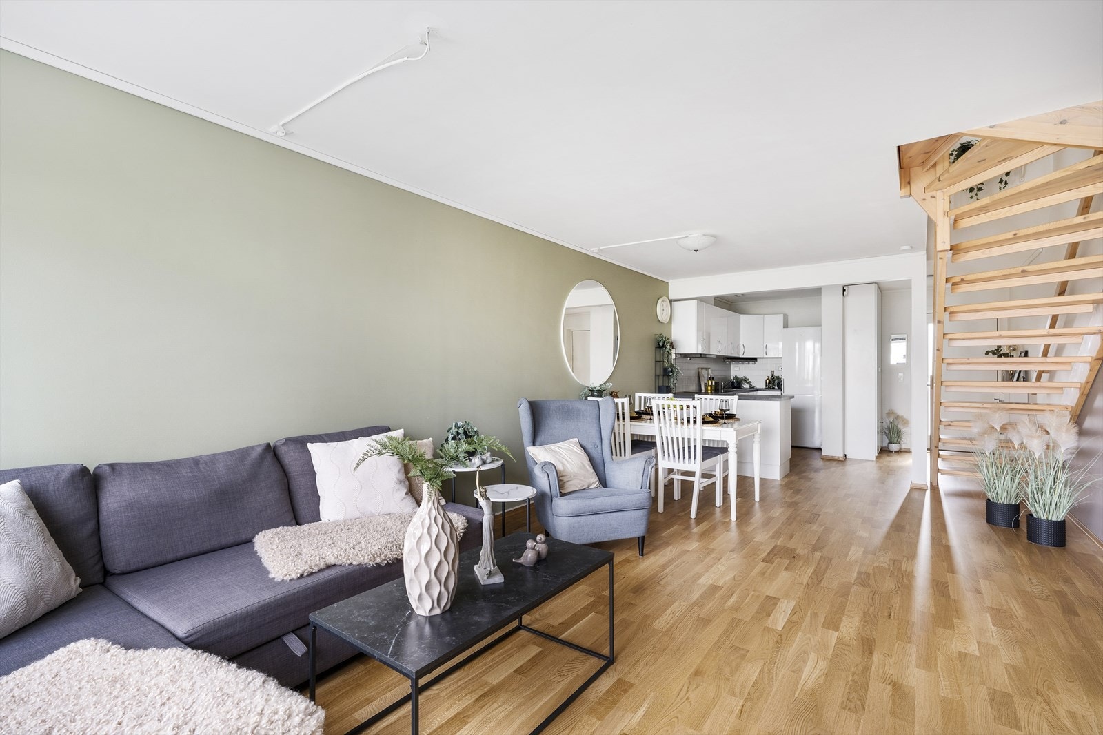 Åpen stue-/kjøkkenløsning med pen eikeparkett på gulv og malte vegger. Galleribilde