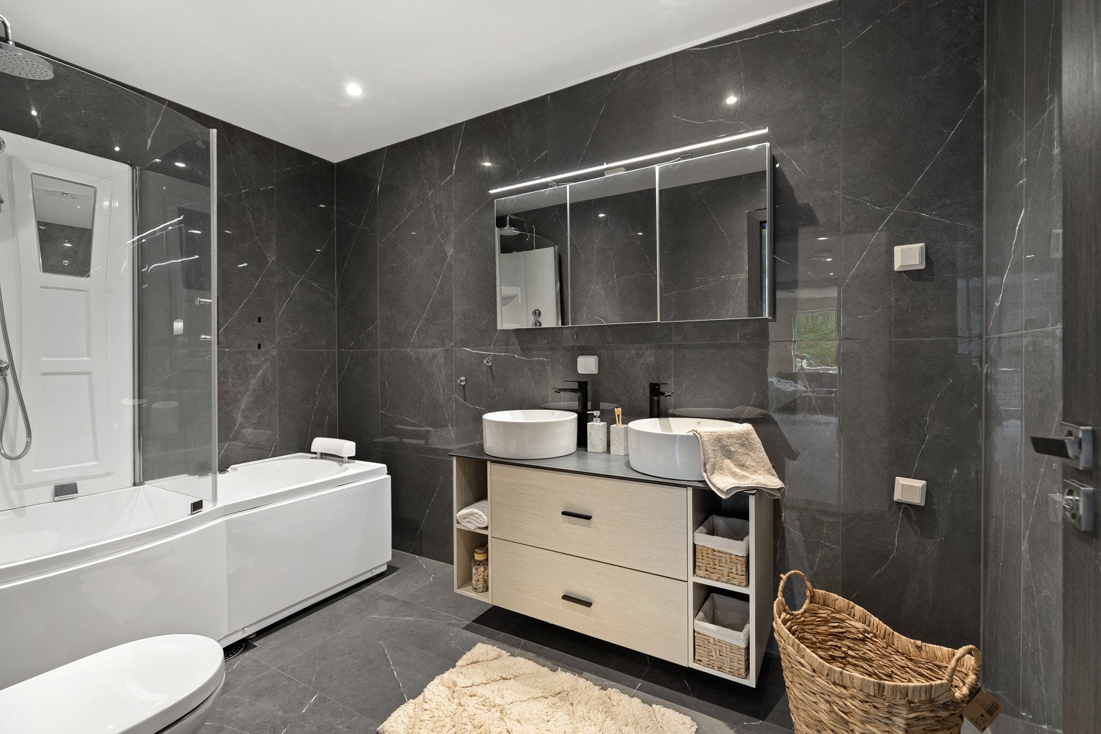 Boligens største baderom har lekre fliser med varmekabler i gulv. Av innredning er det frittstående badekar med boble-/massasjefunksjon. Galleribilde