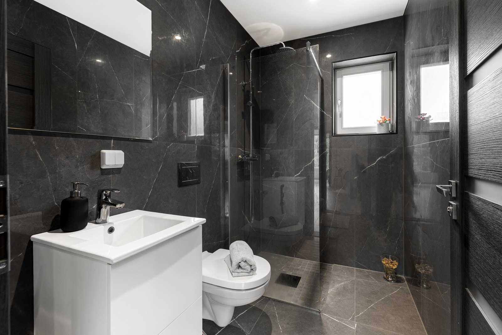 Rommet har lekre mørke fliser med varmekabler i gulv. Nedsenket dusjhjørne med glassvegg og regnfallsdusj. Galleribilde