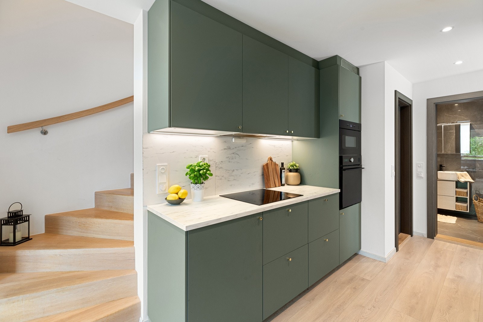 Benkeplate i laminat og integrert induksjonsplatetopp, stekeovn, mikrobølgeovn, oppvaskmaskin og kjøle/fryseskap. Galleribilde