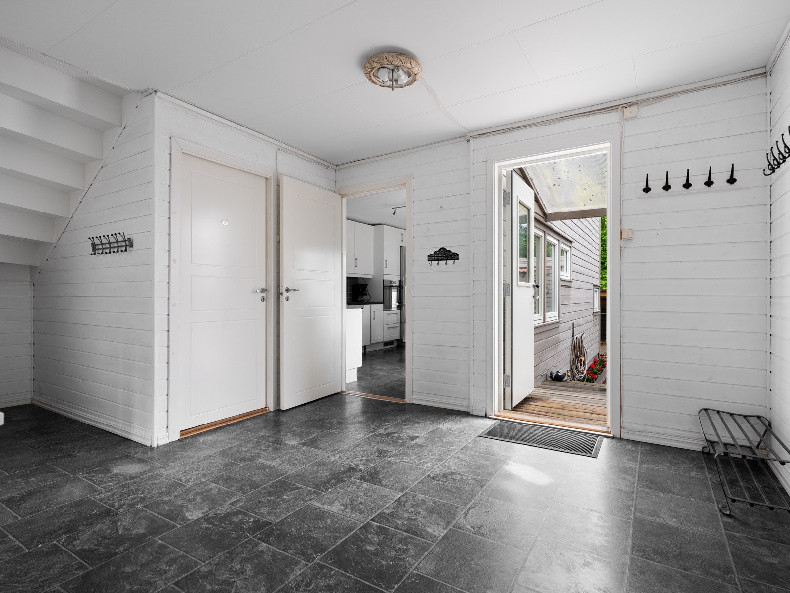 Romslig gang med plass til garderobe eller klesoppheng. Ved siden av trappen har man eget vaskerom med wc Galleribilde