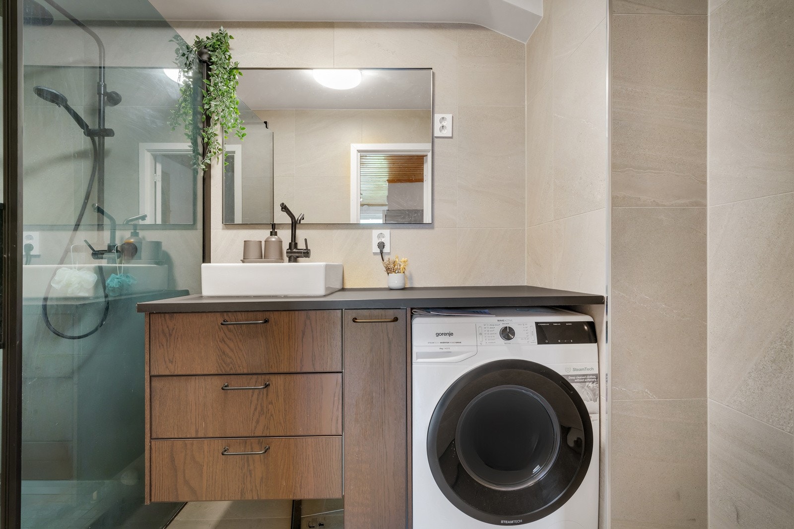 Badet har tidløs utførelse med innredning i imitert tre og store fliser Galleribilde