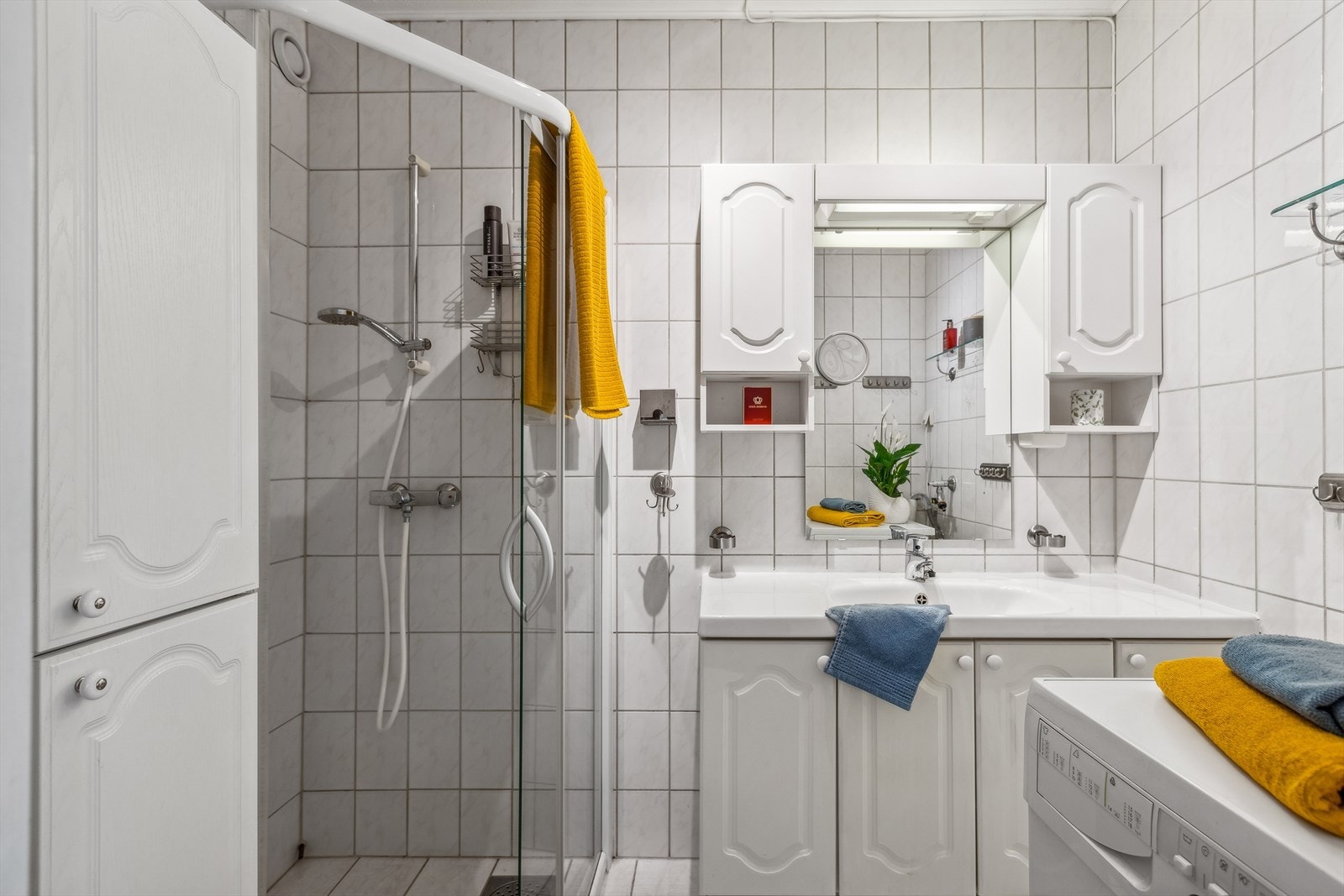 Badet er ca. 3,6 m² og er utstyrt med dusjhjørne, servant med over- og underskap og opplegg for vaskemaskin. Galleribilde