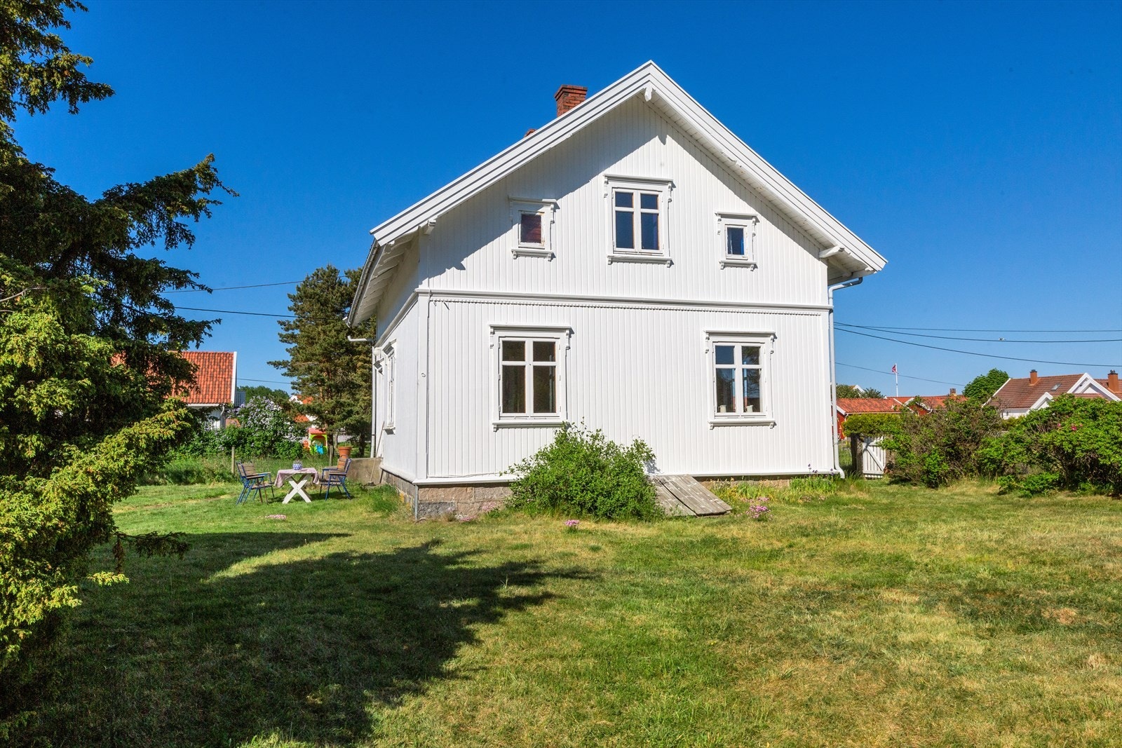 Tomten er solrik og barnevennlig og er opparbeidet med plen og beplantning Galleribilde