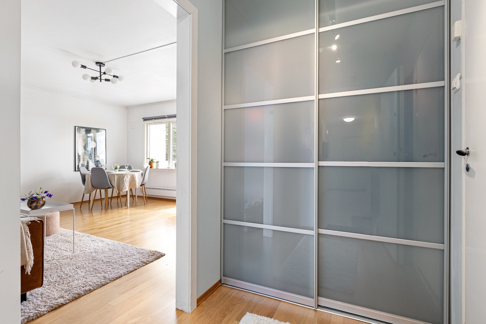 Entréen har parkett på gulvet og malte overflater. Her er det rikelig med oppbevaringsplass i en romslig skyvedørsgarderobe. Galleribilde