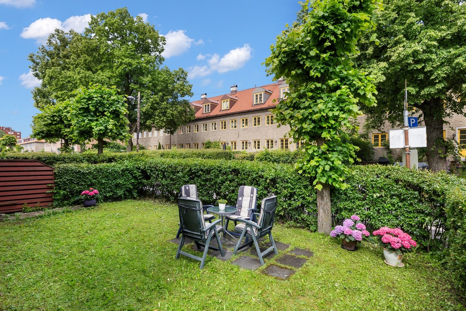 Hagen er opparbeidet med gressplen, busker og friske blomster. Galleribilde
