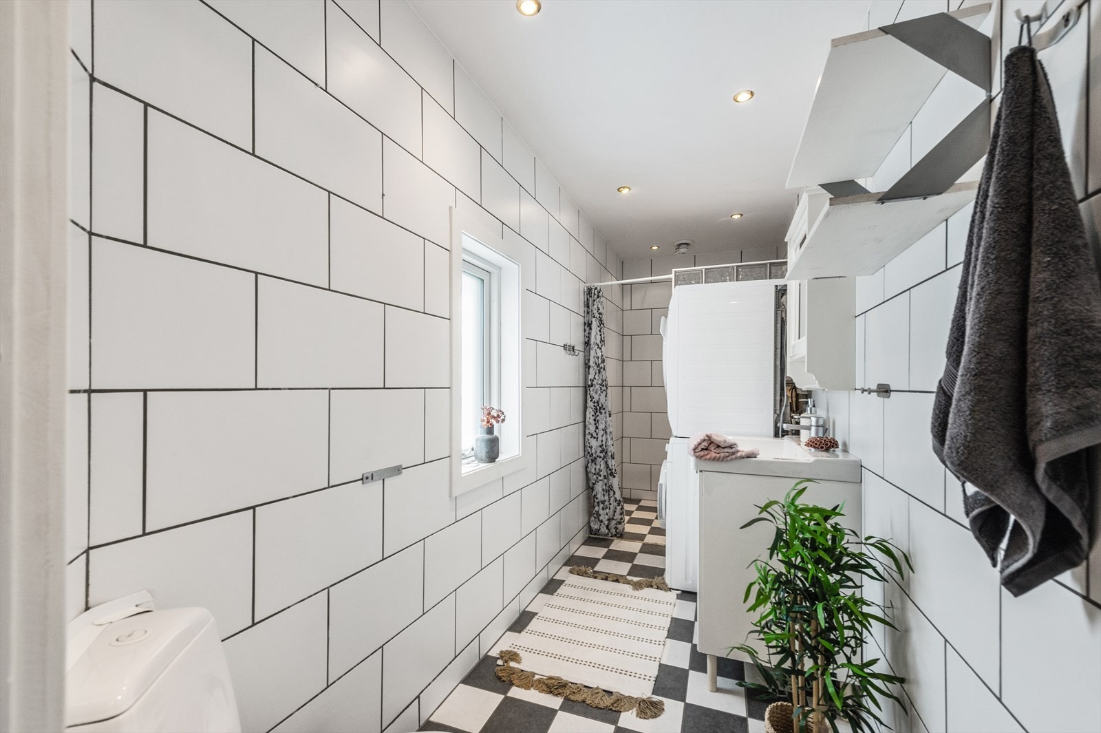 Koselig bad innredet med toalett, servant og dusjnisje. Opplegg for vaskemaskin og tørketrommel. Galleribilde