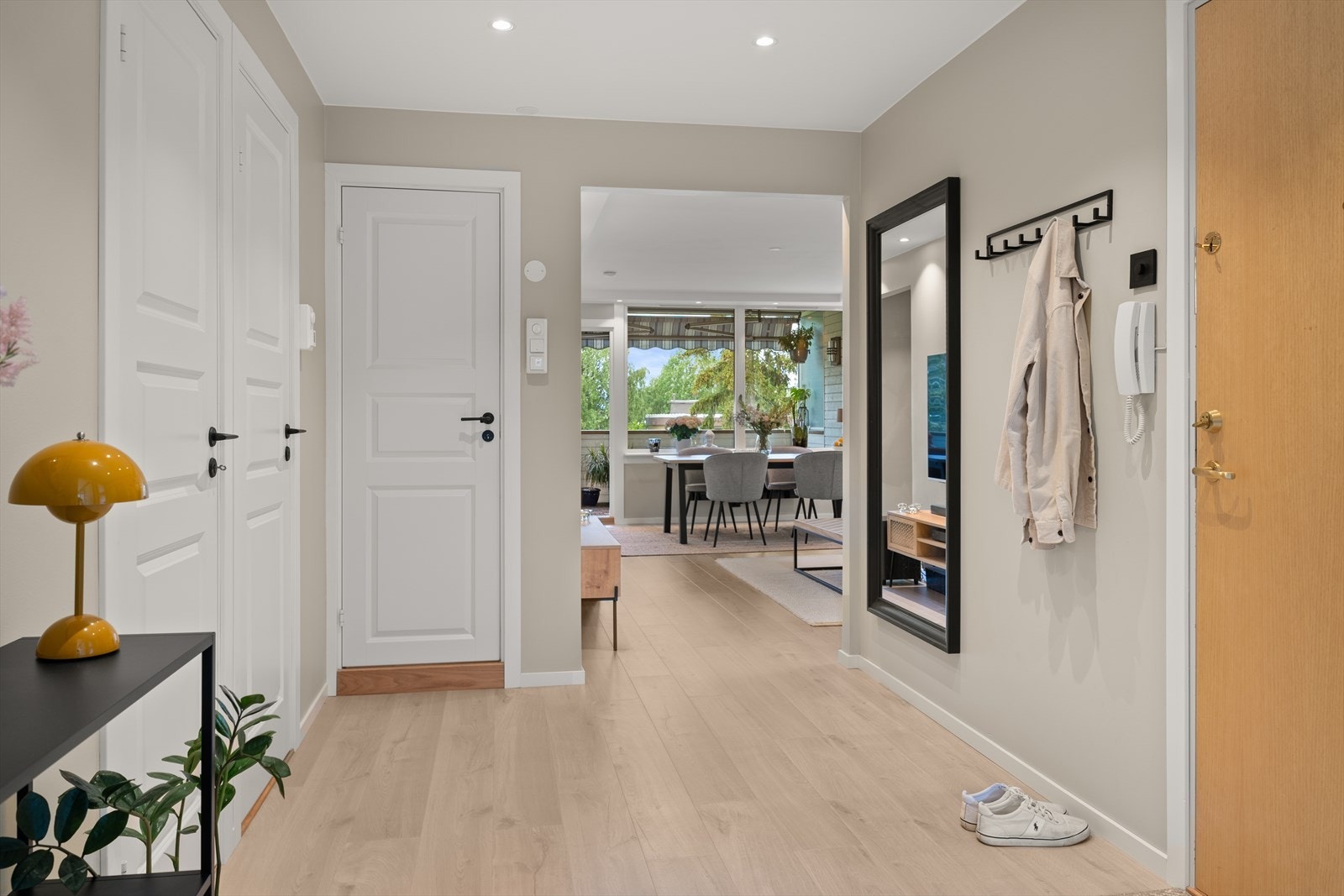 Fin entré med hengeplass til ytterklær og dørcalling på vegg ved inngangsdør. Galleribilde