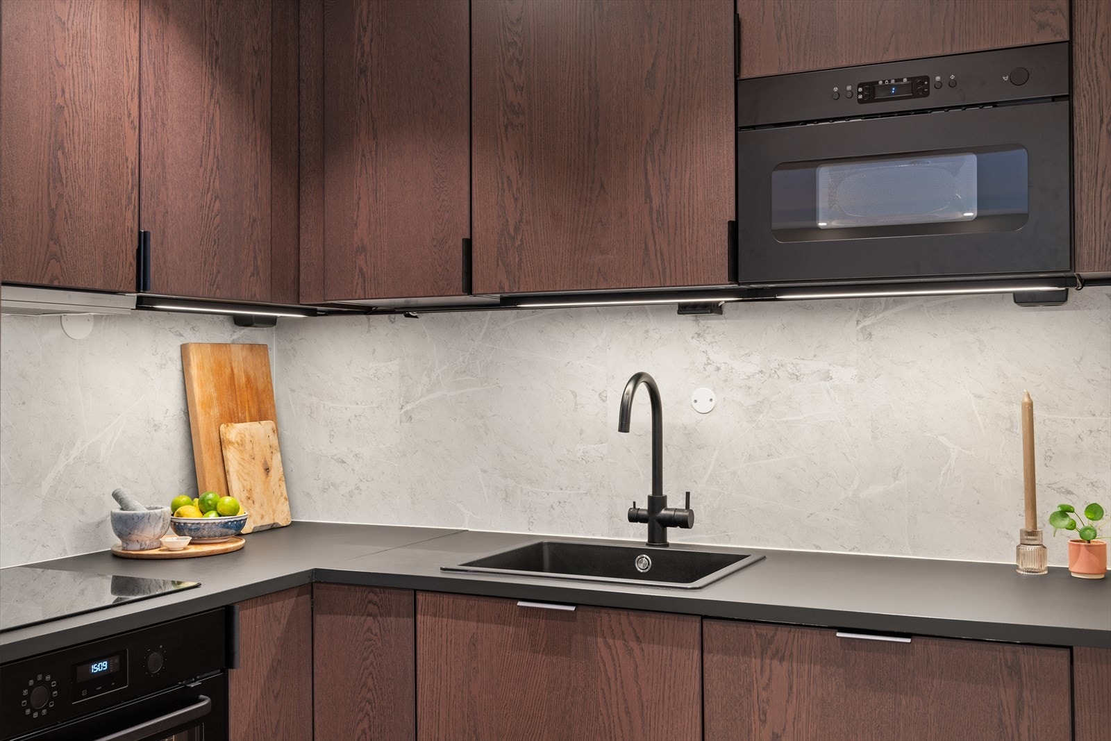 Kjøkkeninnredning med glatte fronter og laminat benkeplate med oppvaskkum og ett greps svingbart blandebatteri. Galleribilde