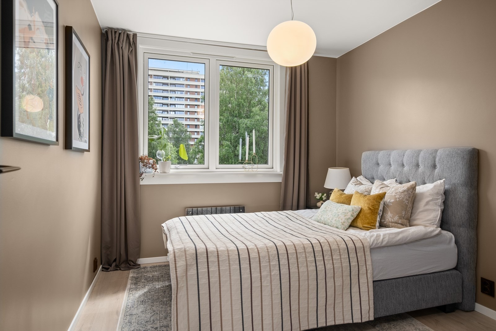 Fint soverom med stort vindu som byr på morgensol Galleribilde