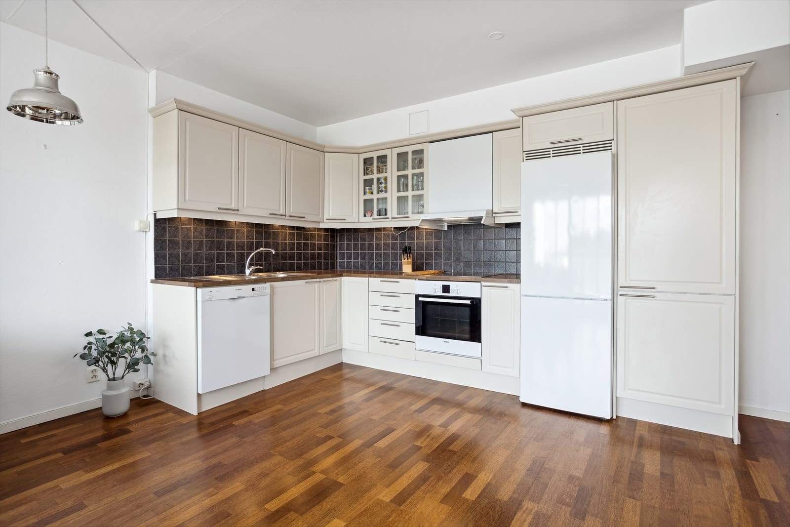 Benkeplater av laminat, vask av stål, fliser over benk. Integrert stekeovn og steketopp. Åpning for oppvaskmaskin og kjøleskap/frys. Galleribilde