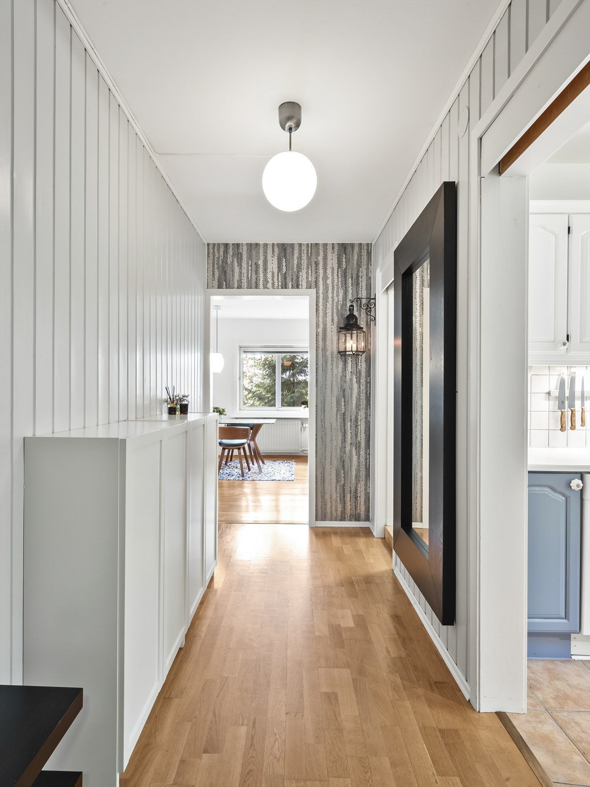Romslig og trivelig entré med parkett på gulv, tapet og malt panel på vegger og malt tak. Ytterdør som er lyd- og brannklassifisert og det er montert dørcallinganlegg slik at man enkelt kan slippe inn gjester. Galleribilde