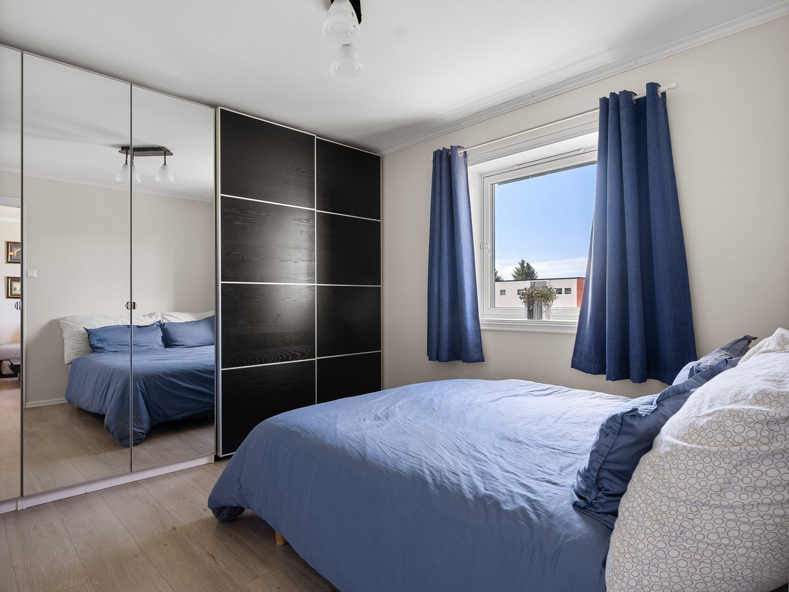 Ett av to soverom, her med stor skyvedørsgarderobe og speil for fin romfølelse. Galleribilde