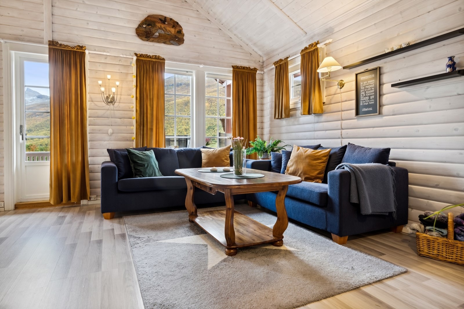 Hytten har en lys og fin stue med et moderne laminat på gulvet og beiset panel på veggene. Galleribilde