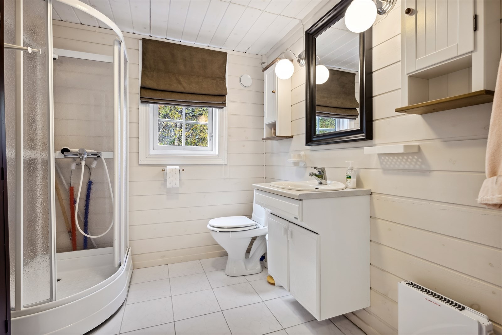 Badet er av fin og lys utførelse med fliser på gulvet og malt panel på veggene. I gulvet er det behagelige oppvarming med varmekabler. Galleribilde