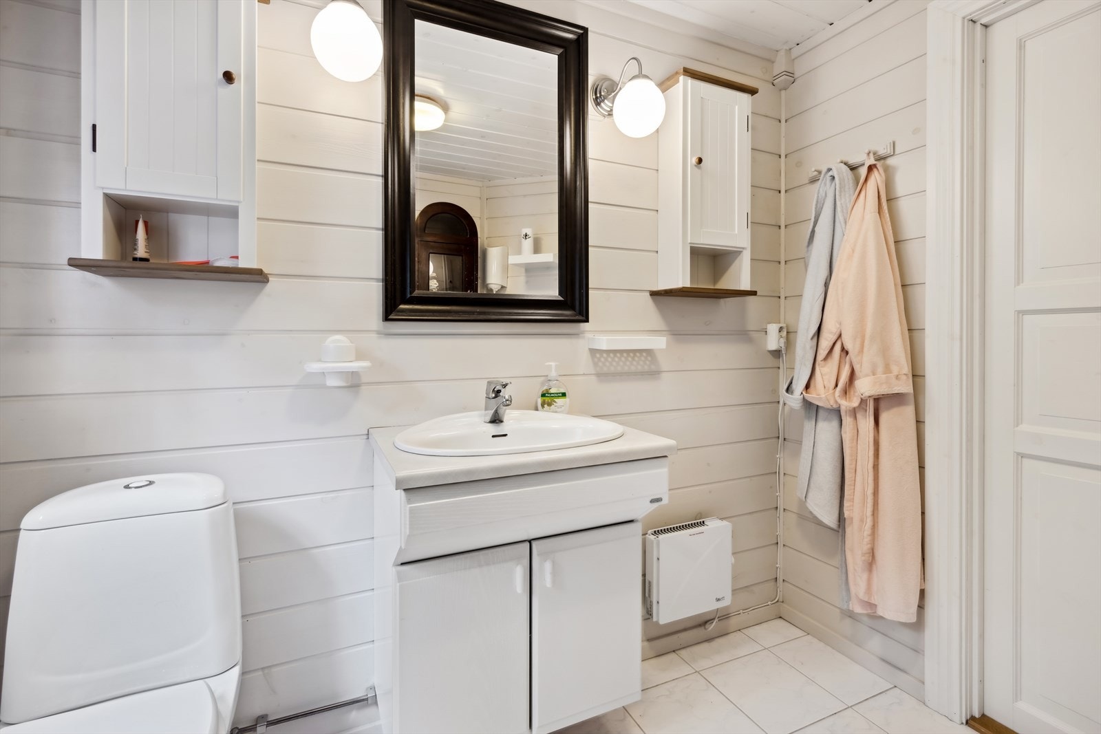 Kommunalt vann og avløp - Badet er utstyrt med toalett, dusjkabinett, servant over innredning og vegghengte skap. Galleribilde