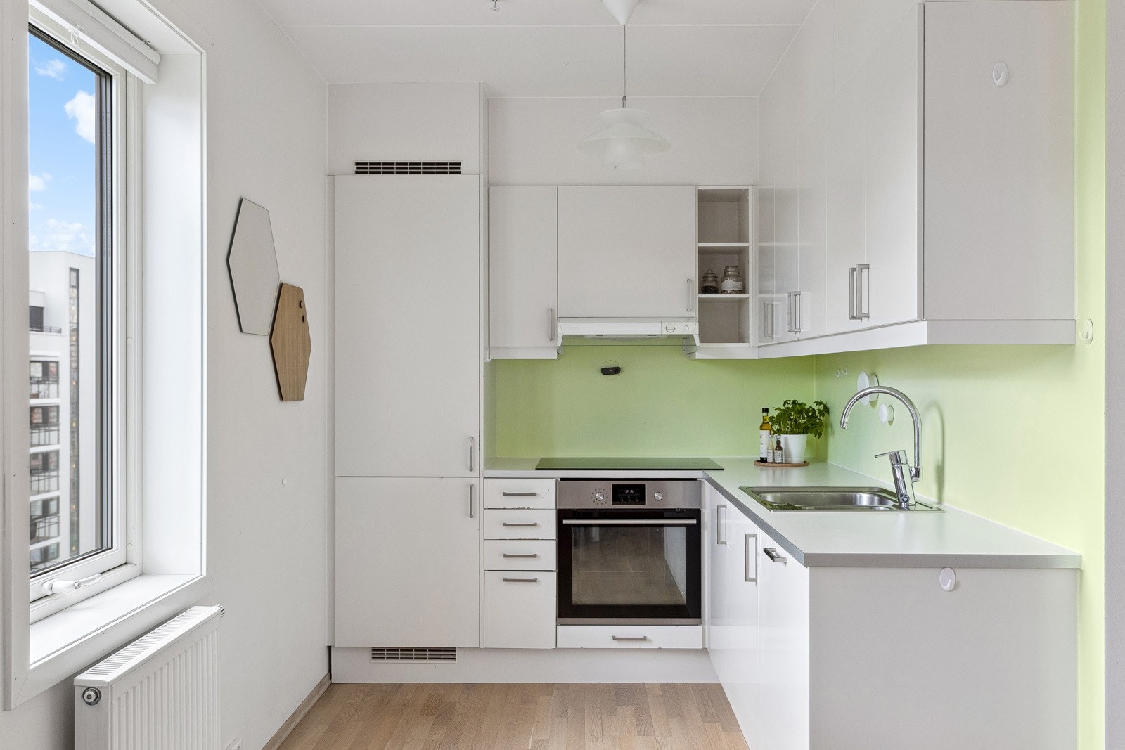 Praktisk kjøkken med integrerte hvitevarer i åpen løsning mot stue Galleribilde