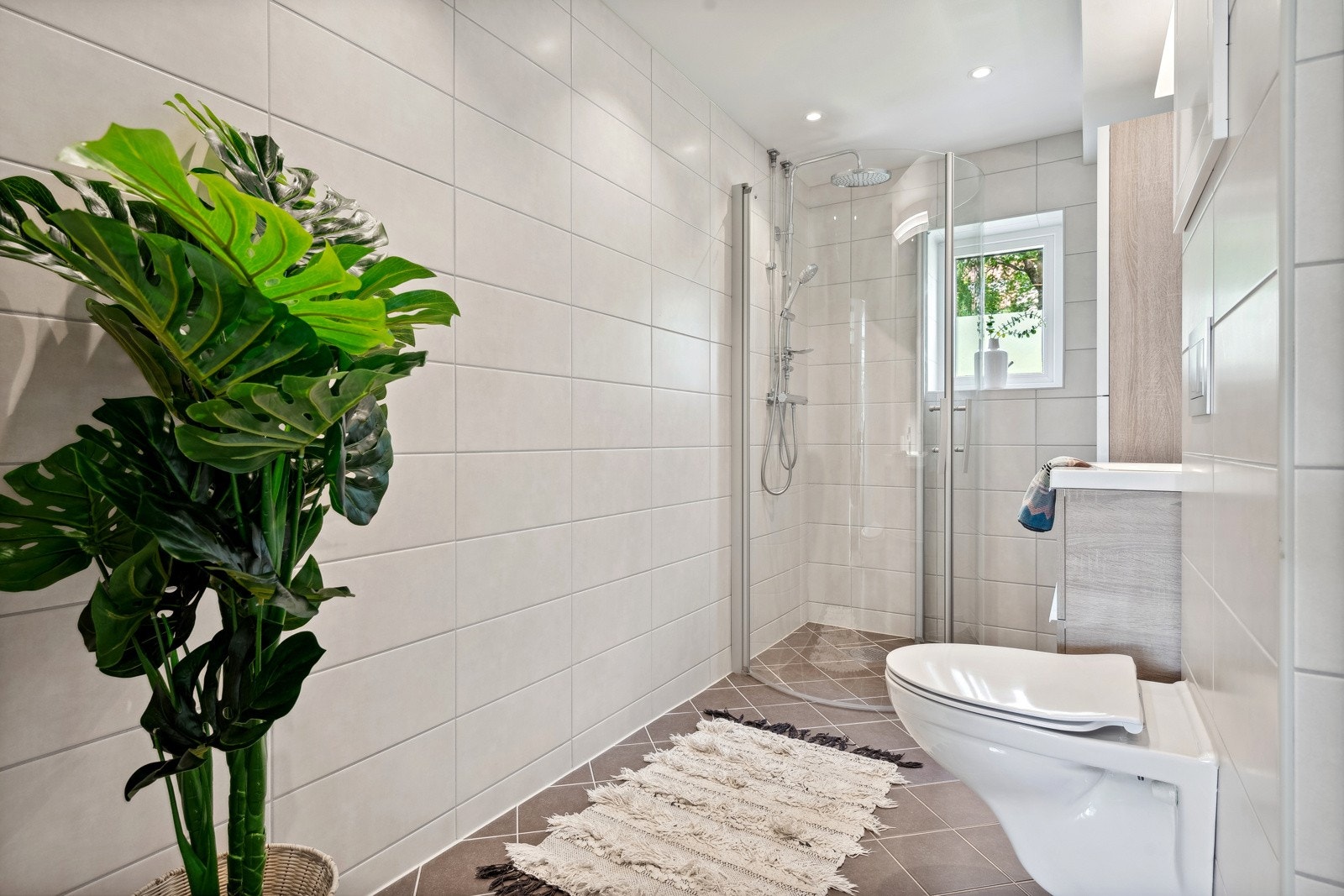 Utvidet bad med gulvvarme, downlights og pen innredning. Regnfalldusj, veggmontert klossett og opplegg for vaskemaskin. Galleribilde
