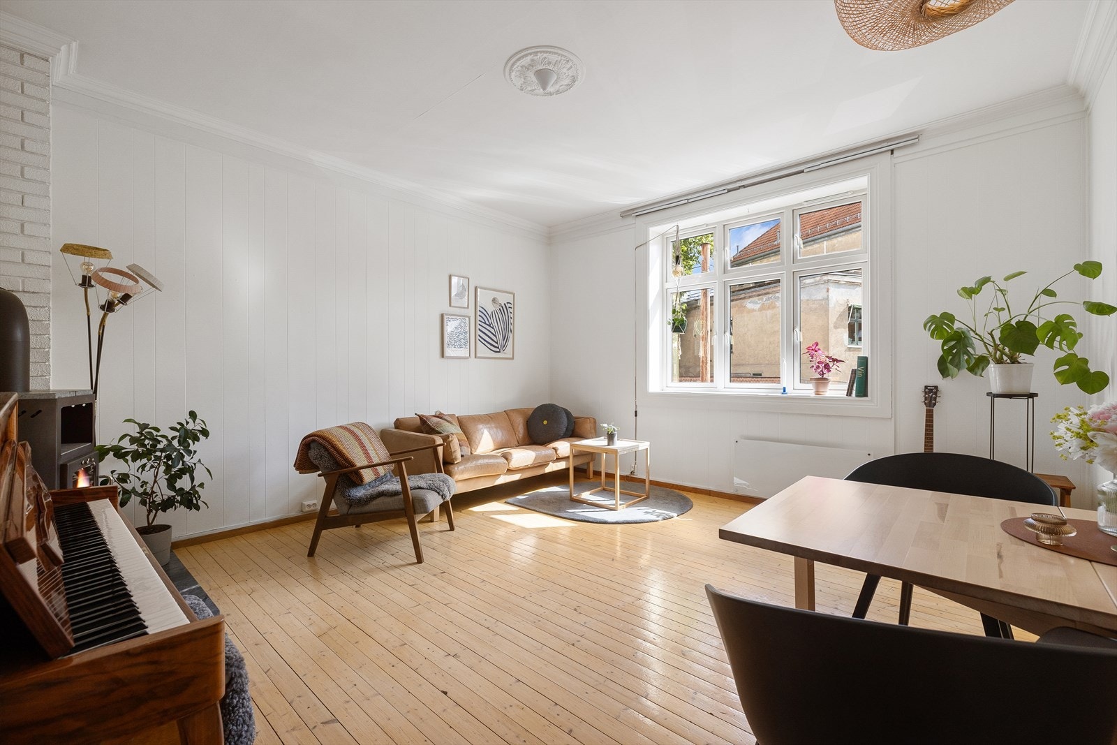 Stuen i leiligheten er romslig og flott opplyst med store vindusflater som gir rikelig med naturlig lys, og skaper en god atmosfære Galleribilde