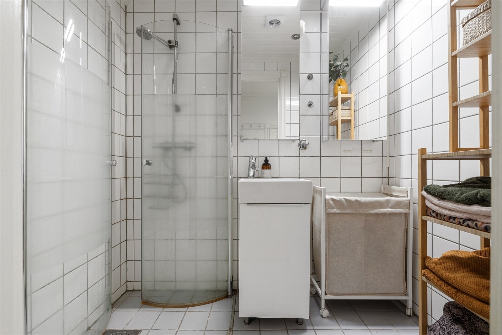 Flislagt bad med termostatstyrte varmekabler som har opplegg for vaskemaskin Galleribilde